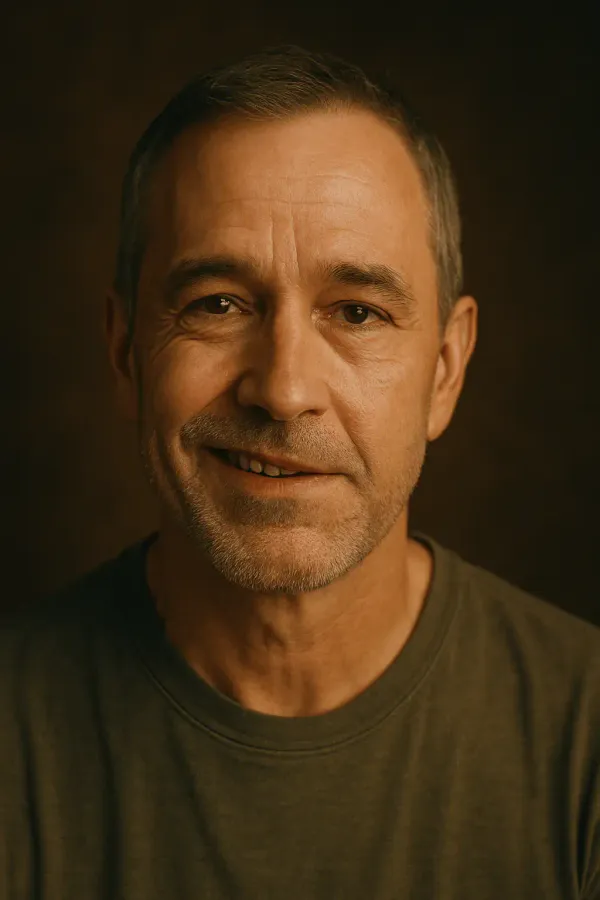 Portrait of a middle-aged man with asymmetrical smile, showing partial facial paralysis and quiet emotional depth.